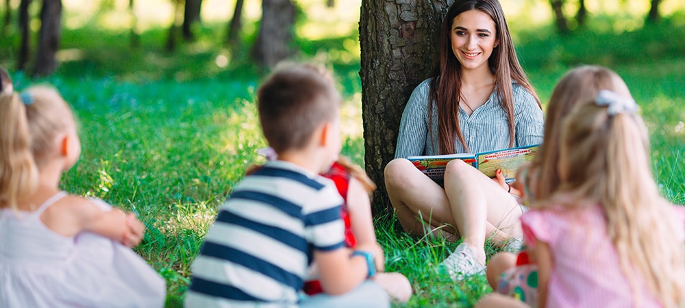 Creative outdoor book club with teacher and pupils