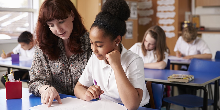 Teacher helping student with classroom work